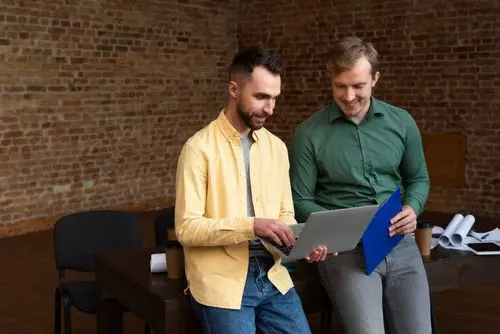 2 personnes assise sur une table qui regarde un document