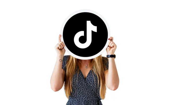 logo Tiktok tenu par une femme devant sont visage