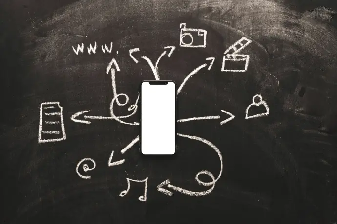 Téléphone portable posé sur un tableau avec des flèches à la crème qui montrent des possibilités de communication