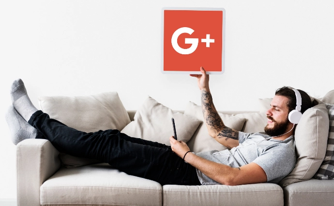 Personne allongée dans un canapé qui tient dans sa main, une pancarte avec le logo de Google